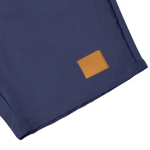 Primo piano di pantaloncini in lino blu navy con trama del tessuto e toppa marrone.