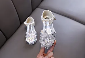Close-up of girls silver princess shoes with rhinestone flower and pearl strap detail