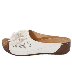 Sandalias de plataforma blancas para mujer con elegante aplique floral y cómoda suela de cuña.