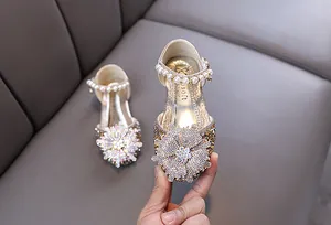 Detail showing shiny rhinestones and pearl strap on gold princess dance shoes for girls.