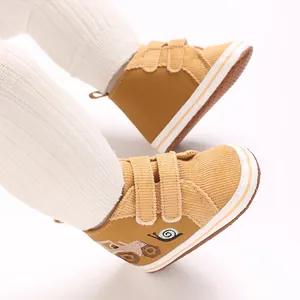 Vista detallada de zapatillas de pana para bebé con tiras de velcro y bordado