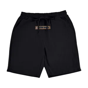 Detailed front view of black men's linen shorts with drawstring waist and logo patch.