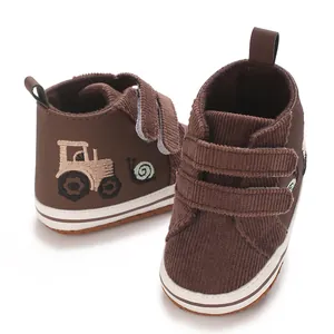 Primer plano de zapatos casuales marrones para bebé con bordado de tractor