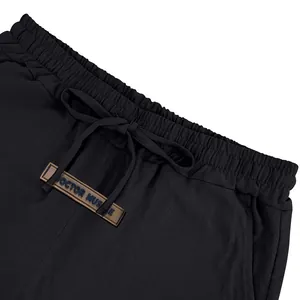 Macro view of men's black linen casual shorts waistband featuring drawstring and brand label
