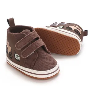 Detalle de zapatos para bebé marrones con bordado de dibujos animados y velcro