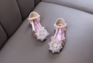 Detail view of pink girls' princess shoes with large rhinestone flower and pearl straps