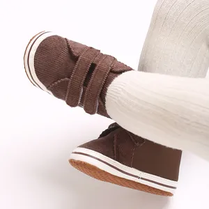 Primer plano de zapatos de pana marrón para bebé con tiras de velcro para infante