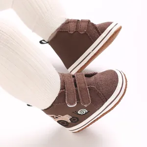 Vista detallada de zapatos de pana marrón para bebé con bordado de caracol lindo
