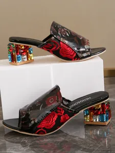 Detalle de sandalias de tacón ancho con pedrería de colores y bordado de rosas.