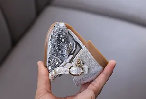 Detail of silver sequin princess shoes with pearl strap and crystal buckle decoration.