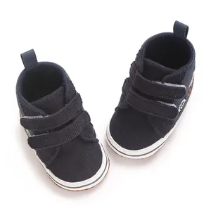Vista detallada de zapatos de bebé en pana azul marino con doble cierre de velcro fuerte.