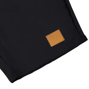Primo piano di pantaloncini in lino nero con dettaglio in pelle marrone sull'orlo
