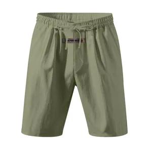Detail view of men's olive green linen shorts with drawstring waist and logo patch