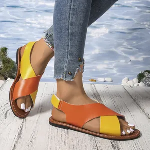 Primer plano de sandalias planas cruzadas para mujer en amarillo y naranja