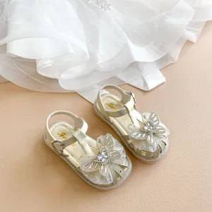 Detailansicht weißer Mädchensandalen mit Strass-Schmetterlingsbögen und weichen Sohlen