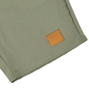 Dettaglio di pantaloncini di lino da uomo con orlo e applicazione quadrata