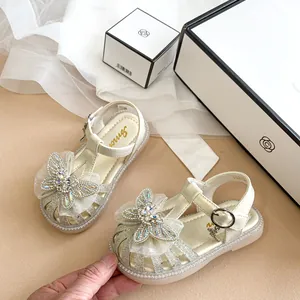 Detailansicht silberne Glitzersandalen für Mädchen mit Strass-Schmetterling und weicher Sohle