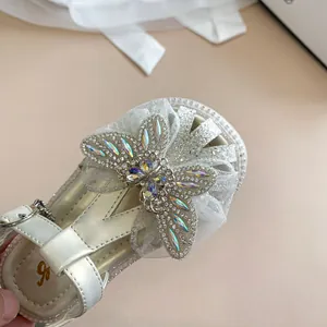 Detailansicht der glitzernden Strass-Schmetterlingsverzierung an Mädchen-Sandalen