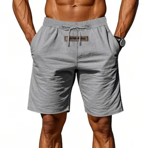 Close-up of men's gray linen drawstring shorts with a 'DOCTOR MUSCLE' logo patch.