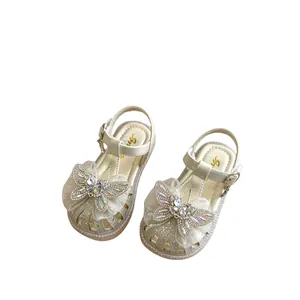 Glitzernde Sandalen für Mädchen mit Strass-Schmetterling-Dekoration auf weißem Hintergrund