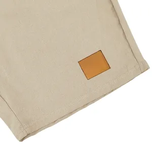 Dettaglio del tessuto in lino traspirante e della toppa in pelle sui pantaloncini