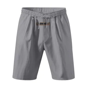 Detailed view of grey linen-blend casual shorts featuring a drawstring waist and logo patch.