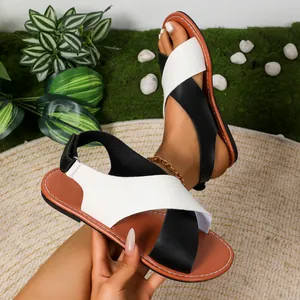 Primer plano de sandalias romanas planas con tiras cruzadas en blanco y negro