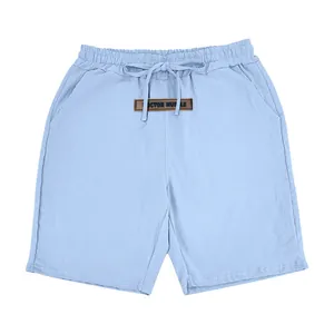 Light blue men's linen shorts with elastic drawstring waist and brown leather patch