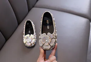 Detailed view of girls' sparkling rhinestone princess dress shoes with flower accent