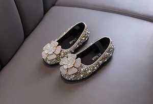 Detail of girls' gold rhinestone princess flats with large flower ornament