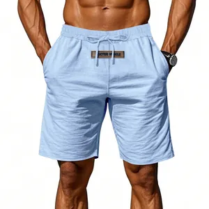 Macro view of men's blue drawstring shorts with 'DOCTOR MUSCLE' patch detail
