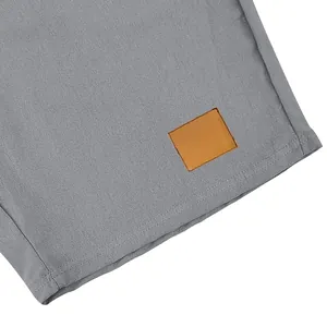 Dettaglio ravvicinato dei pantaloncini di lino grigi con trama del tessuto e patch