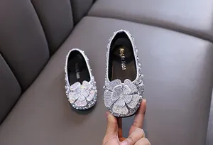 Macro detail of silver rhinestone-encrusted girls' princess shoes for dance.