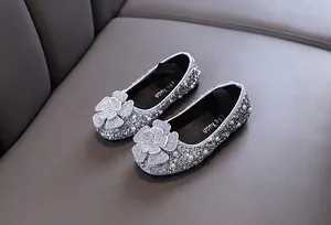 Detail of silver girls princess shoes with sparkling rhinestones and pearl flowers