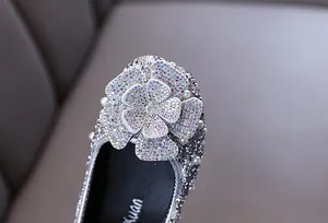 Detailed macro shot of silver toddler princess flats with a large rhinestone flower