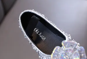 Close-up detail of sparkling silver toddler princess shoes with rhinestones and pearls