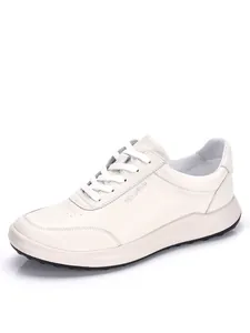 Primer plano de zapatillas casuales de cuero blanco para hombre con suela blanda.