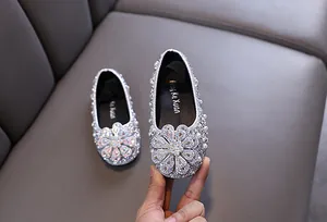 Macro view of silver glitter princess shoes for girls with rhinestone flower detail