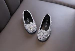 Detailed view of silver girls princess shoes with sparkling rhinestone flower decoration