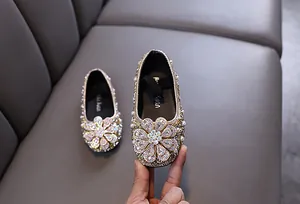 Detailed view of sparkly gold rhinestone flower on girl's princess dress shoes