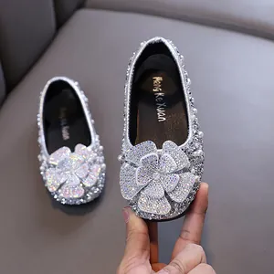 Elegant silver glitter girls princess shoes featuring a rhinestone flower and pearl details