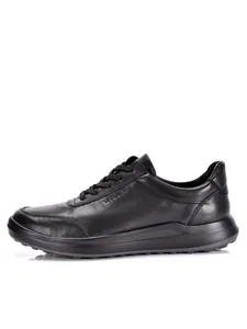 Vista lateral detallada de la zapatilla de cuero negro premium con la suela y textura.