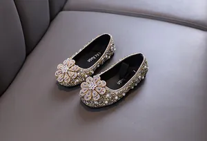 Close-up of sparkling girls' rhinestone princess shoes with a floral pearl detail