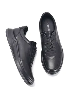 Vista detallada superior y lateral de zapatillas casuales de cuero genuino negro para hombres.