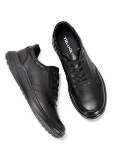 Draufsicht auf hochwertige schwarze Herren-Sneaker aus genarbtem Leder mit weicher Sohle