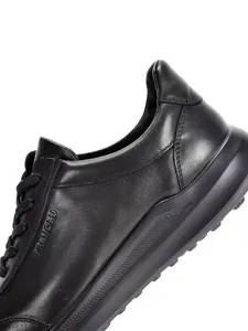 Primer plano de la textura de cuero negro premium y costuras finas en zapato casual de hombre