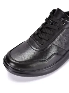 Detailaufnahme von hochwertigem, schwarzem Leder mit Lychee-Struktur an Herren-Sneakern