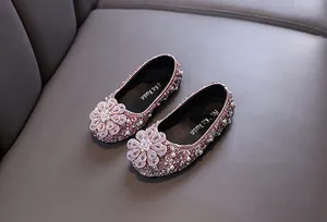 Detailed macro view of pink girls' princess shoes with rhinestones and pearls