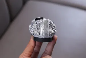 Close-up detail of rhinestone and pearl embellishments on girl's princess shoes