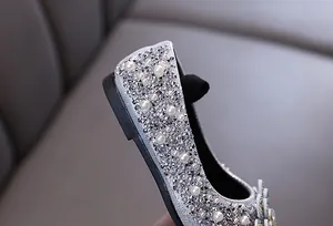 Detailed close-up showing silver rhinestones and pearls on girls princess shoes